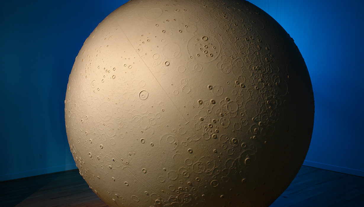 Image of a moon sculpture against a blue background