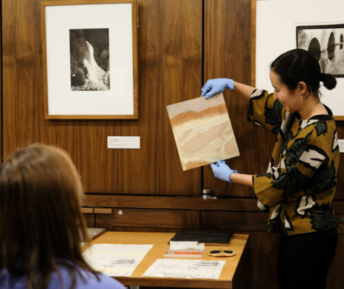 UMMA Curator Natsu Oyobe shows artwork to a study room visit.