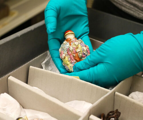 An art handler manipulates a Chinese art object