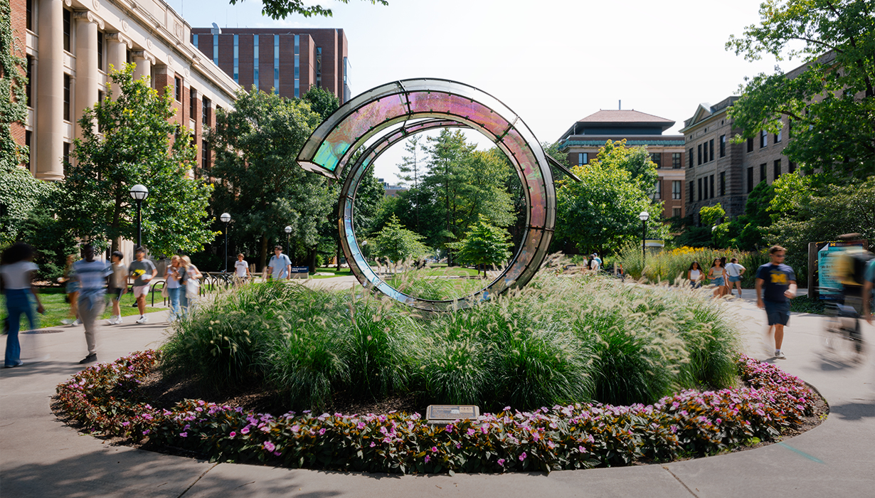 Students walk past the Arriving Home Sculpture.