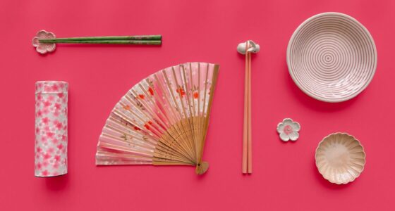 Flatlay of spring-inspired items arranged on a vibrant pink background. From left to right: a cylindrical tea canister decorated with pink cherry blossoms, a pair of green chopsticks resting on a pink flower-shaped chopstick holder, a pink and floral folding hand fan, a pair of pink chopsticks resting on a bunny-shaped chopstick holder, a cream-colored bowl with concentric pink rings, a beige dish with petal-like ridges, and a small white and pink flower-shaped chopstick holder.