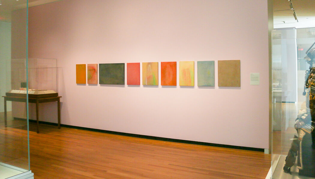 Manika Magare's paintings are displayed on a light pink wall in UMMA's Japanese Gallery space.