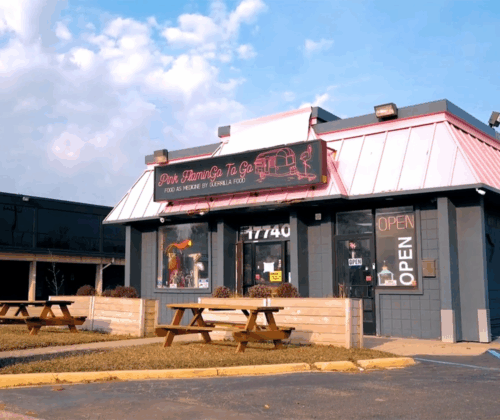 Pink Flamingo restaurant outside view with black building and pink roof.