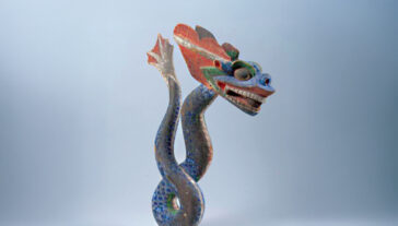A carved wooden dragon on a blue background