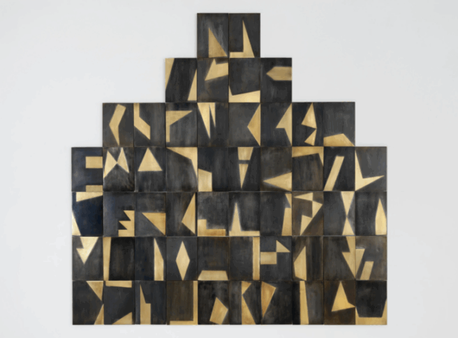Fifty-four rectangles of identical size, each with a distinct arrangement of brass on black metal, arranged in the shape of a stepped pyramid.