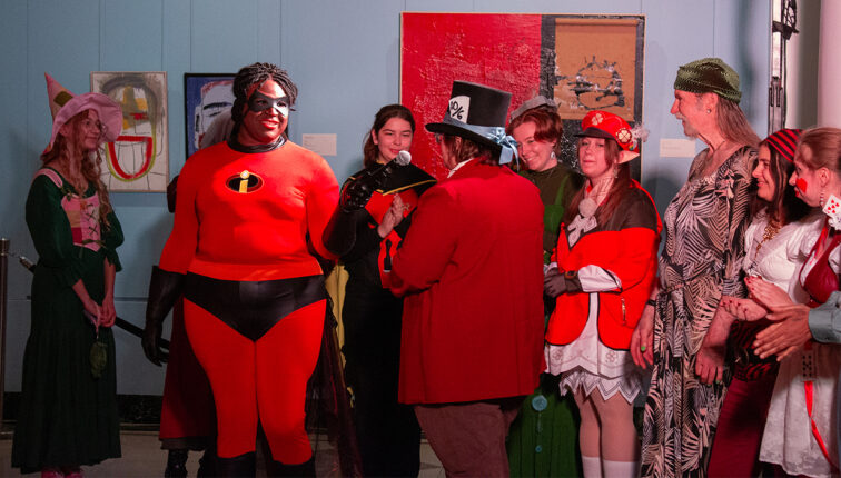 Group of people in costumes, including someone dressed as Mr. Incredible from The Incredibles.