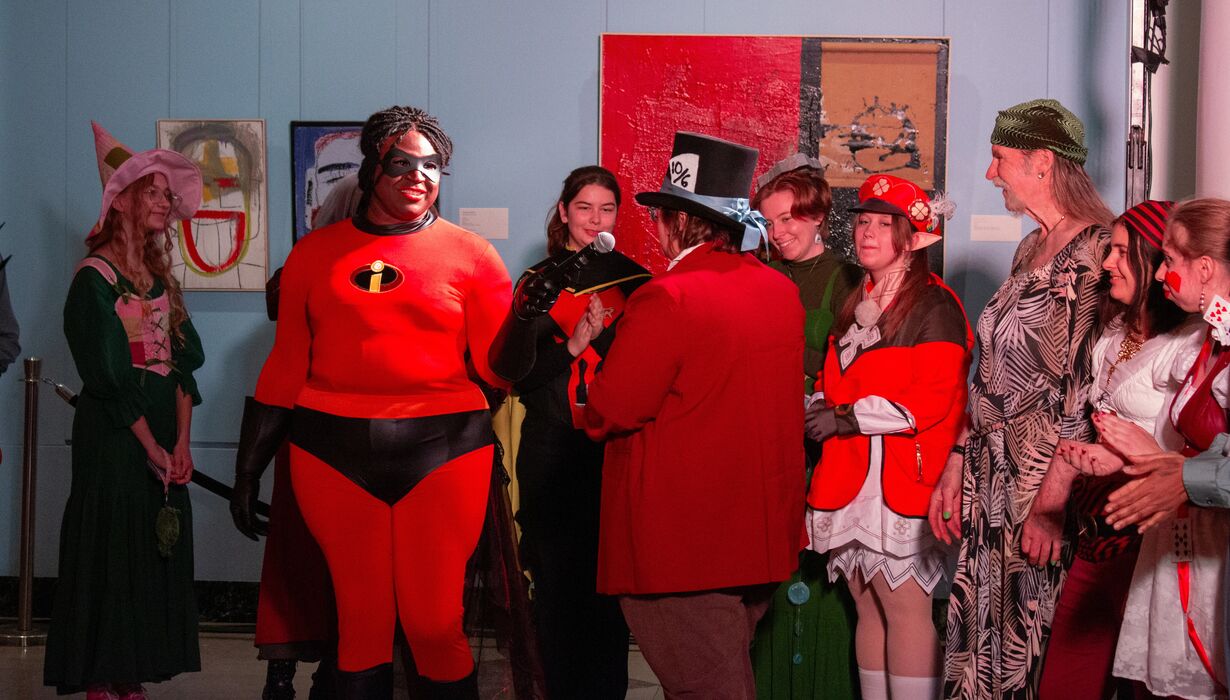 Group of people in costumes, including someone dressed as Mr. Incredible from The Incredibles.