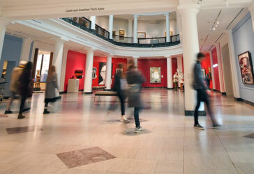 Tile floor in foreground with people in motion walking throughout the space.