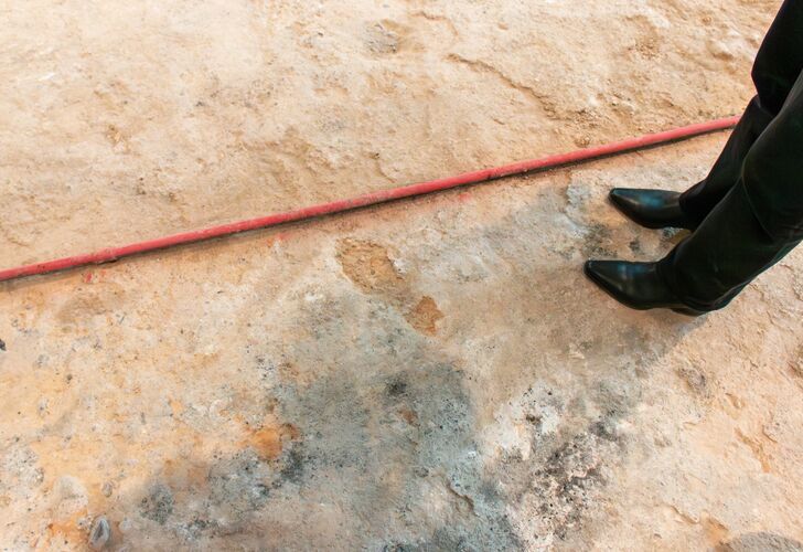 A large atrium room mid construction project - wheelbarrows and torn up tile are littered around.
