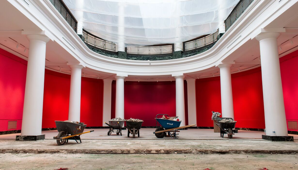 A large atrium room mid construction project - wheelbarrows and torn up tile are littered around.