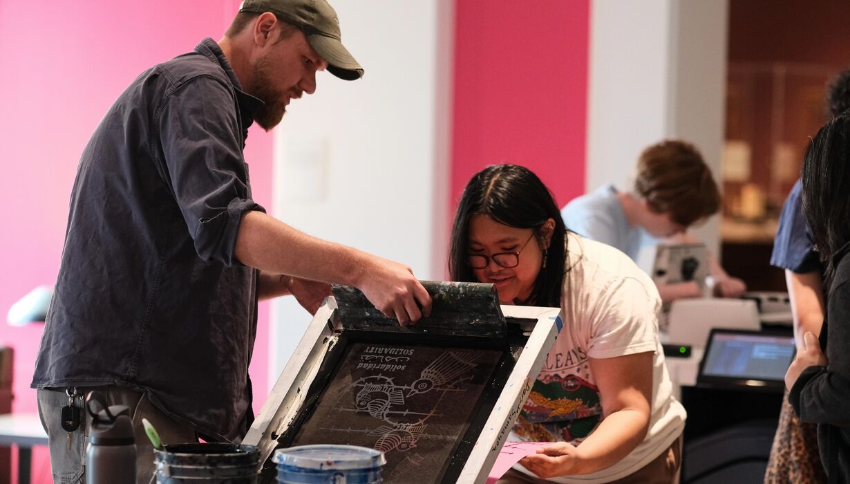 Two people making a silkscreen print.