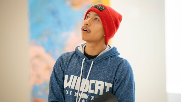 Museum visitor looks up at artwork with inspired gaze.