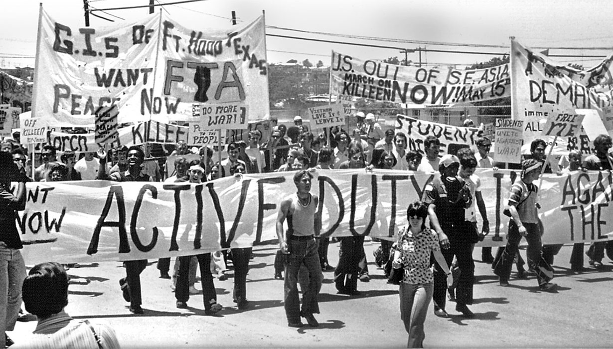 Frame from movie, "Sir! NoSir!" showing people at a protest with many protest banners being shown.
