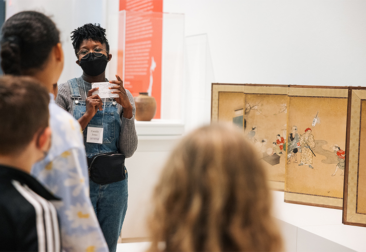 Elementary students engage with art and educators during a tour of an art museum