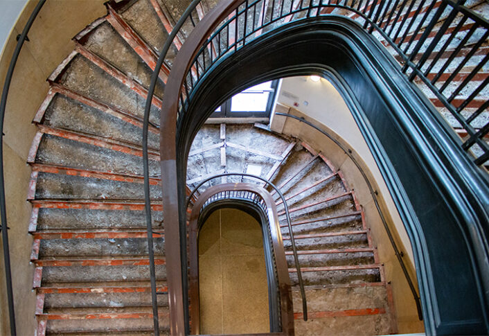 A large staircase is under renovation, exposing the unfinished material underneath.