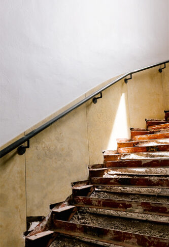 A large staircase is under renovation, exposing the unfinished material underneath.