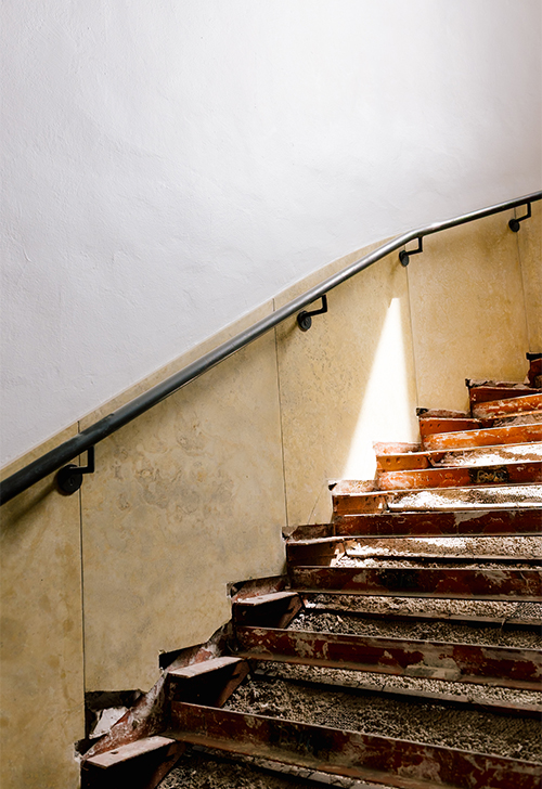A large staircase is under renovation, exposing the unfinished material underneath.