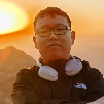A portrait of a man against an orange sunset