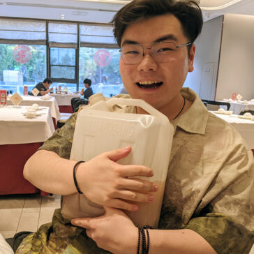 A man holding a gallon jug half-full of liquid